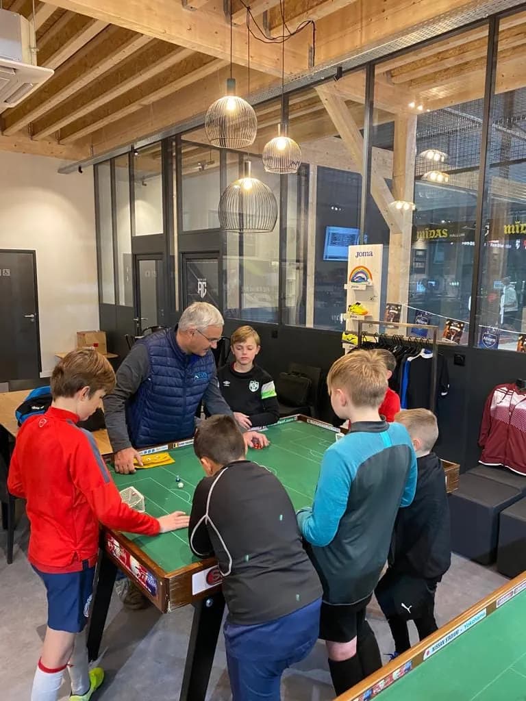 Des enfants s'initient au football de table autour d'une table de jeu à l'Aréna Club d'Halluin
