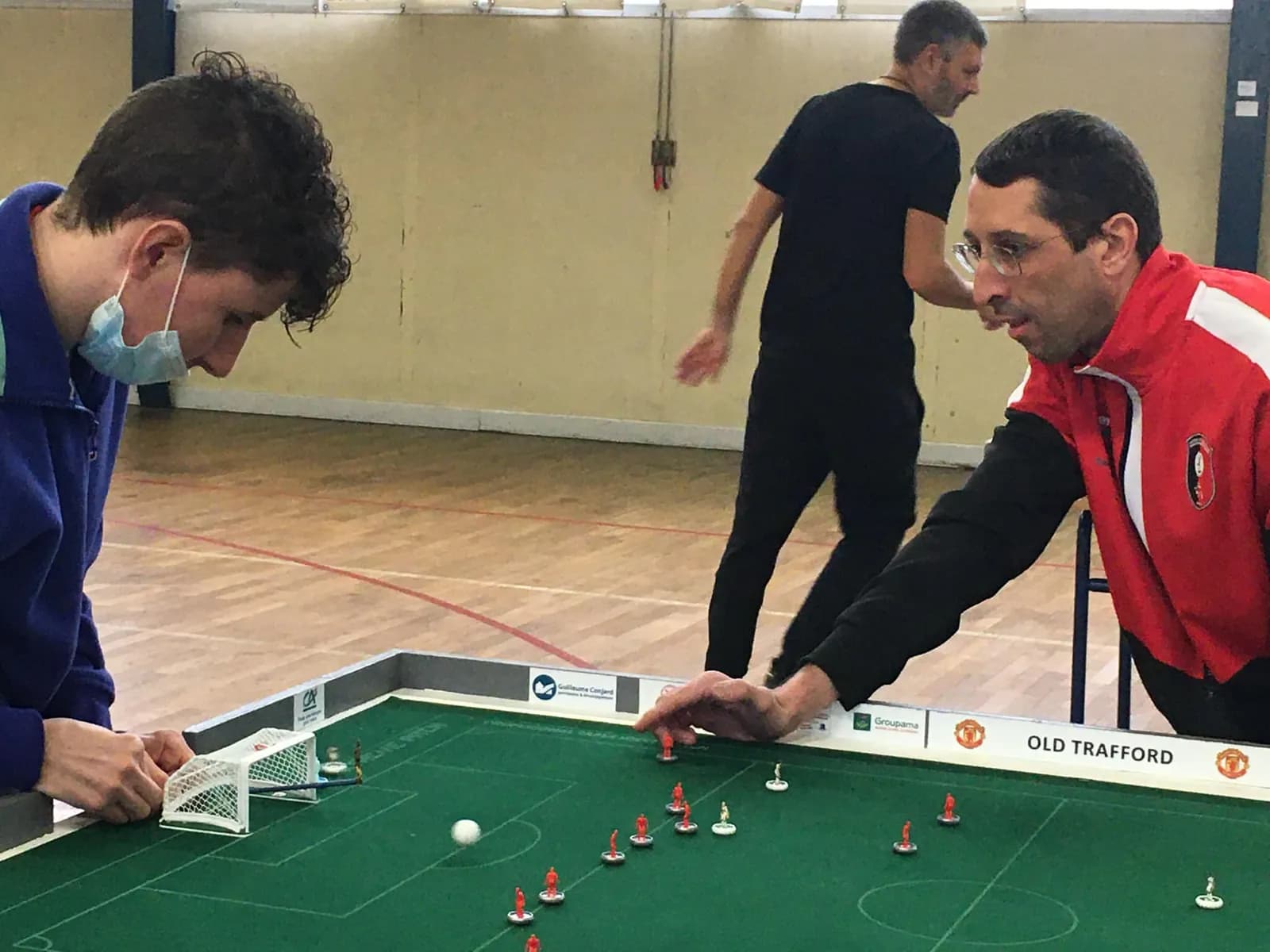 Deux joueurs penchés sur une table de jeu pendant le derby OL - ASSE