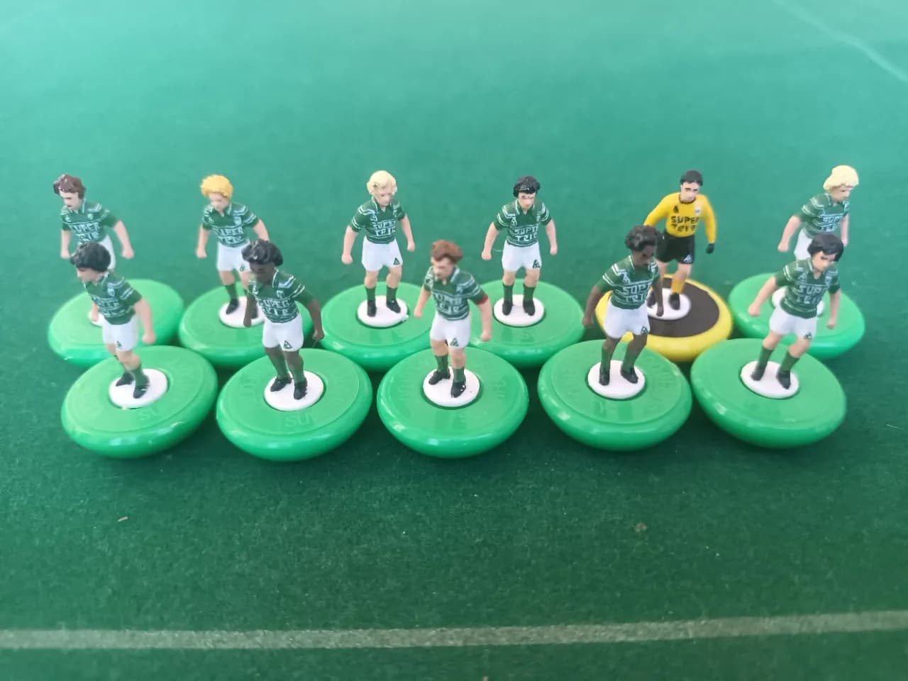 Équipe de figurines aux couleurs vertes de l'AS Saint-Étienne 1981, alignée sur un terrain